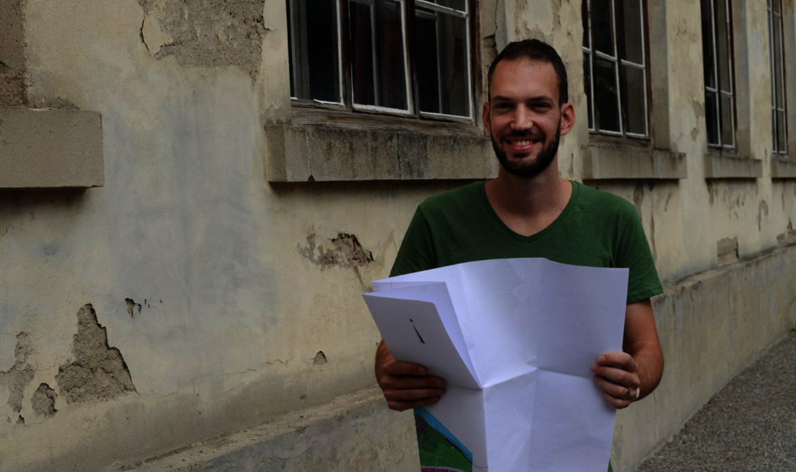 Junger Mann mit aufgefaltetem Stadtplan