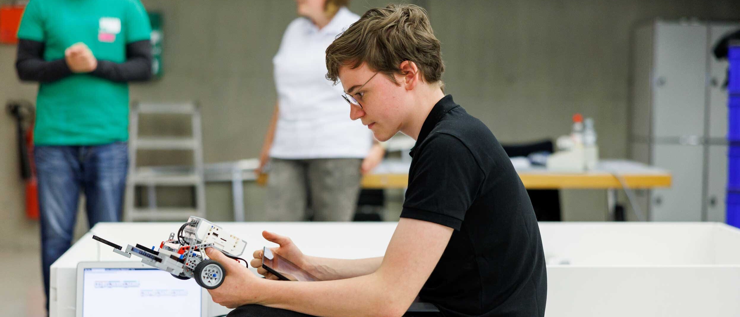 Ein Schüler prüft seinen Roboter vor dem Wettkampf