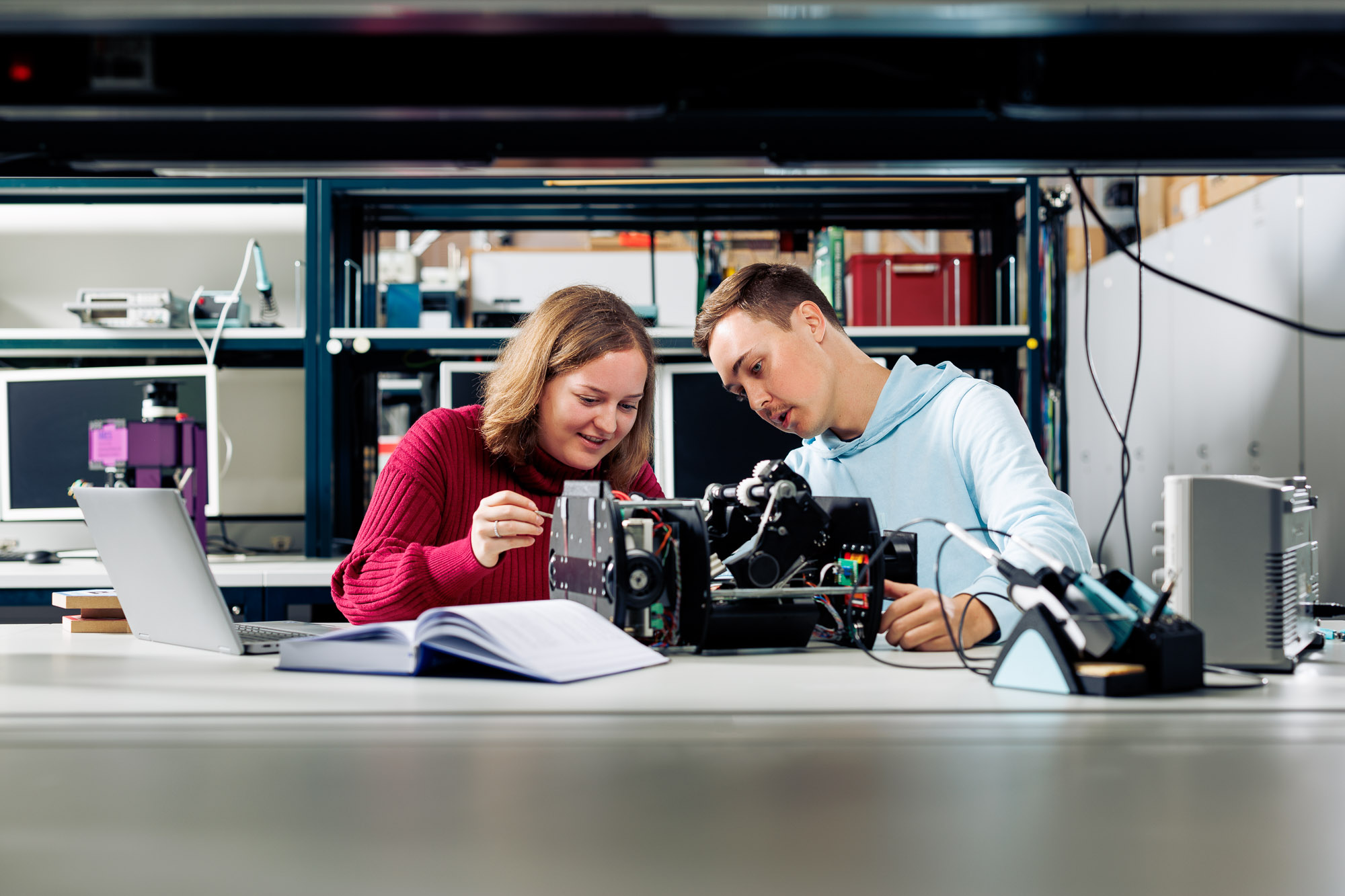 Zwei Studierende des Studiengangs Electrical and Computer Engineering arbeiten im Labor an der OST an einem Roboter.