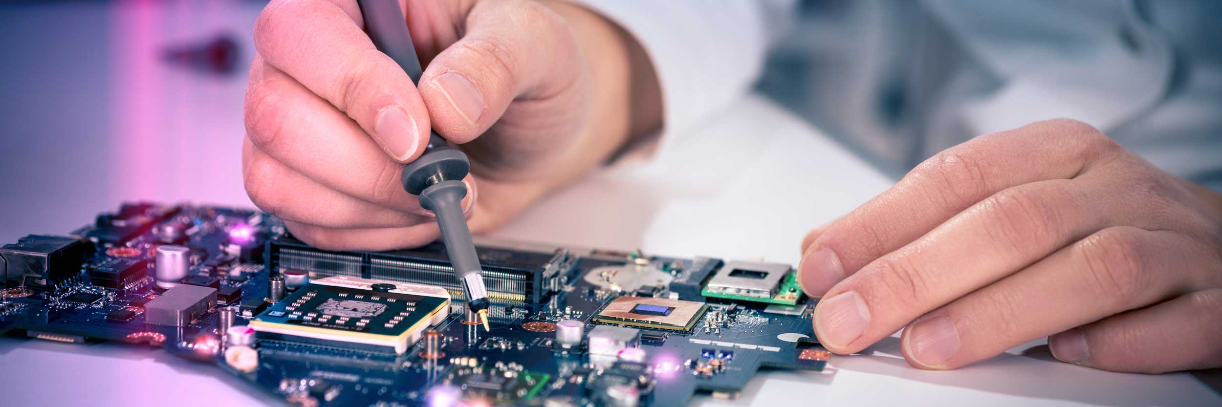 Hand mit Lötkolben und Elektronik-Platine