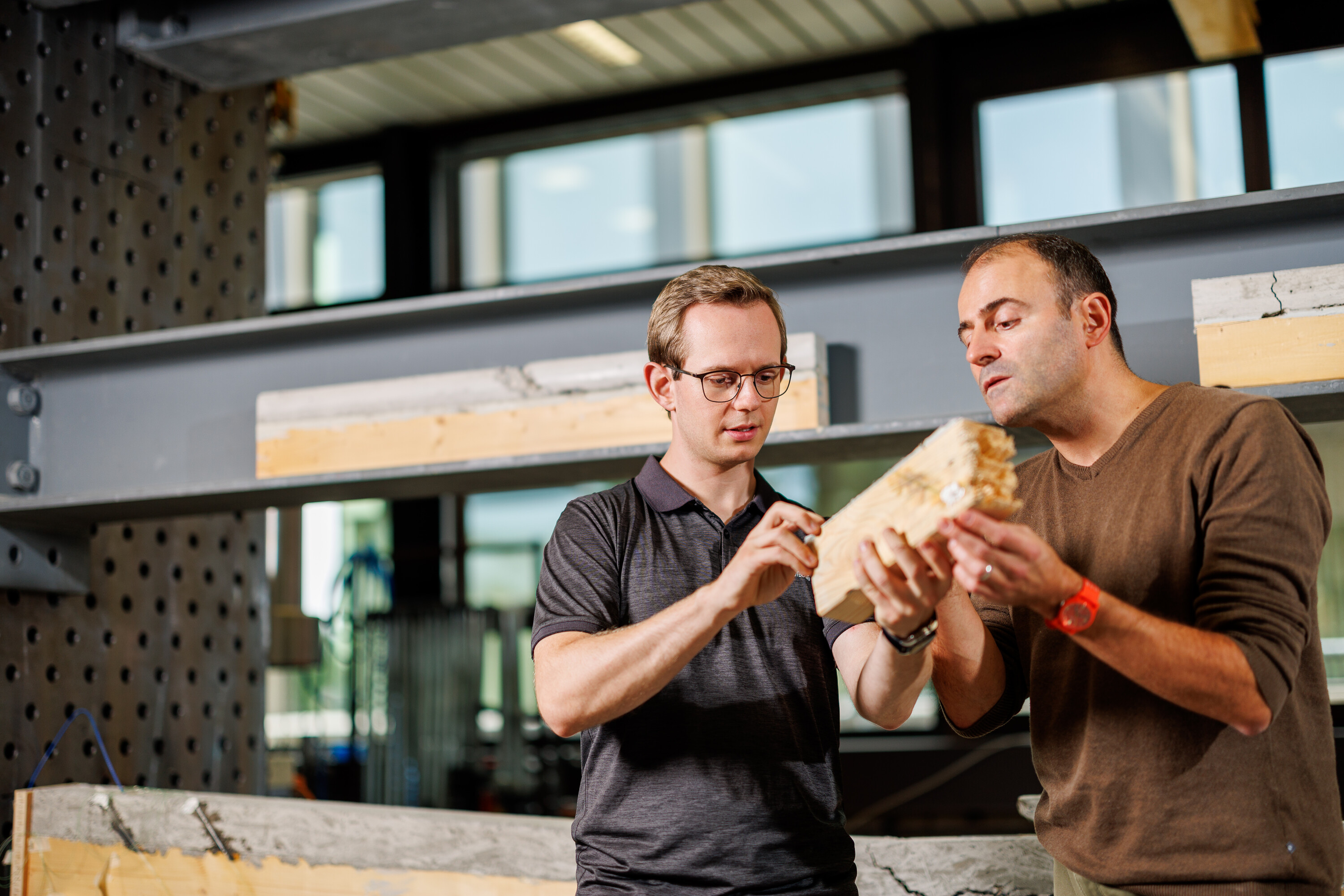 Zwei Männer schauen einen gebrochenen Holzbalken an (Symbolbild für Master Civil Engineering (MSE ) )