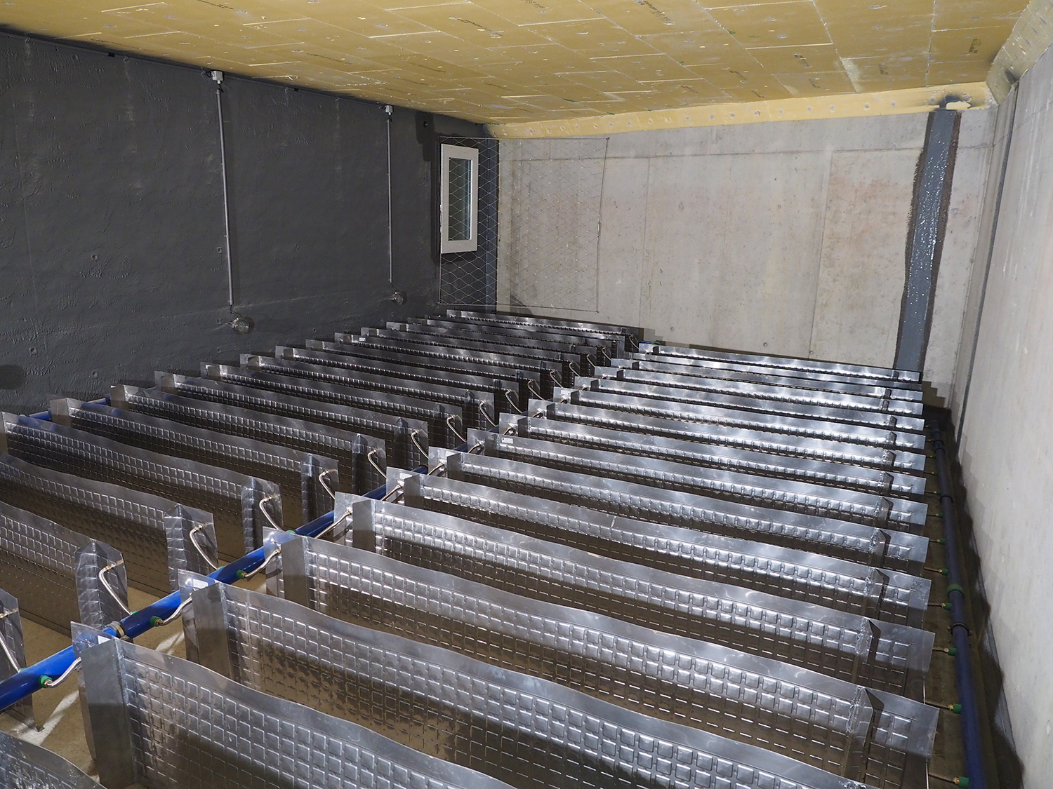 Die metallenen Wärmetauscher im Inneren des Eisspeichers laden den Speicher bei Bedarf mit Sonnenenergie auf oder entziehen ihm Wärme (Aufnahme vor dem Befüllen mit Wasser).