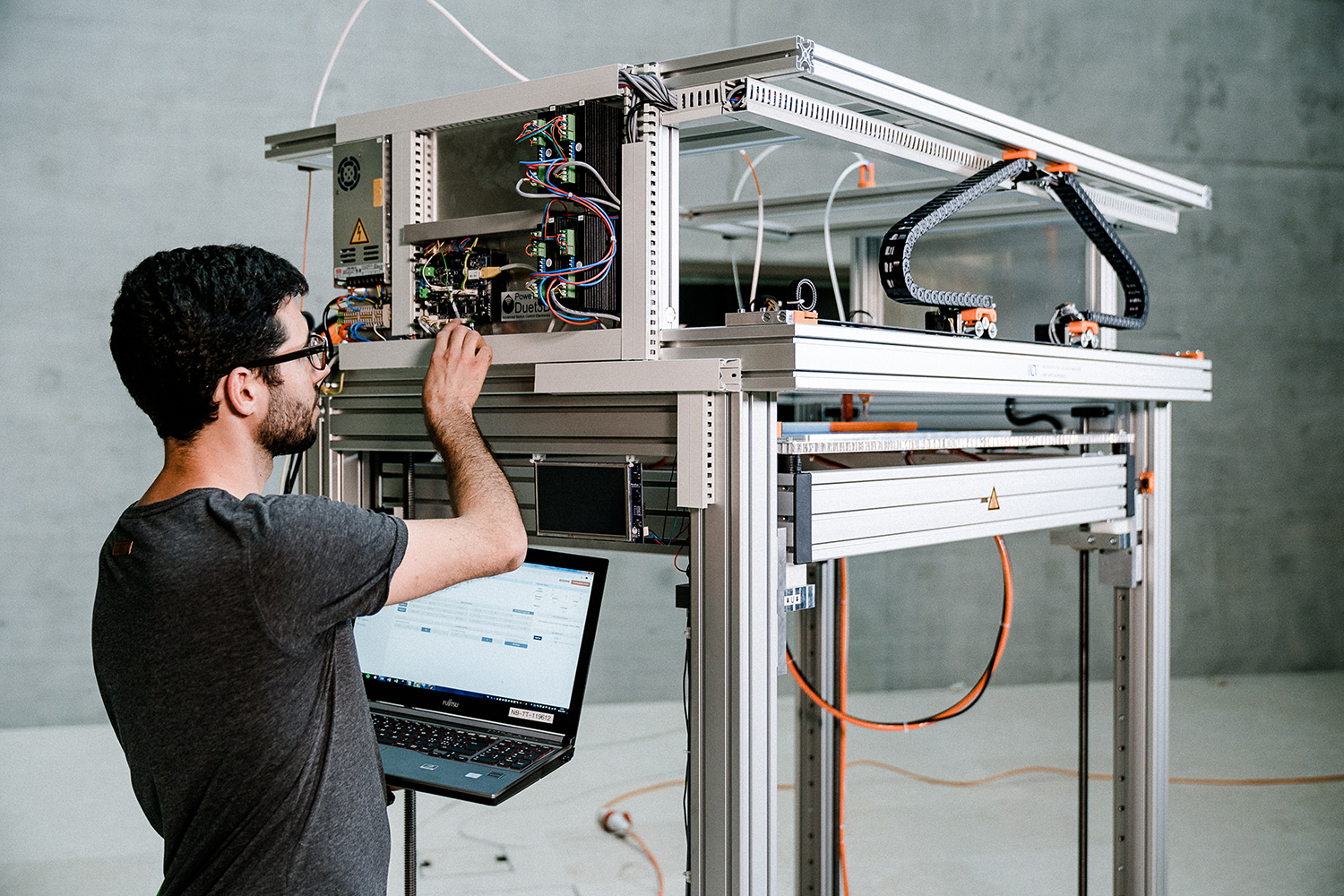 Marco Rossi nimmt noch einige Einstellungen am 3D-Drucker vor, bevor er an die ETH Zürich ausgeliefert wird.